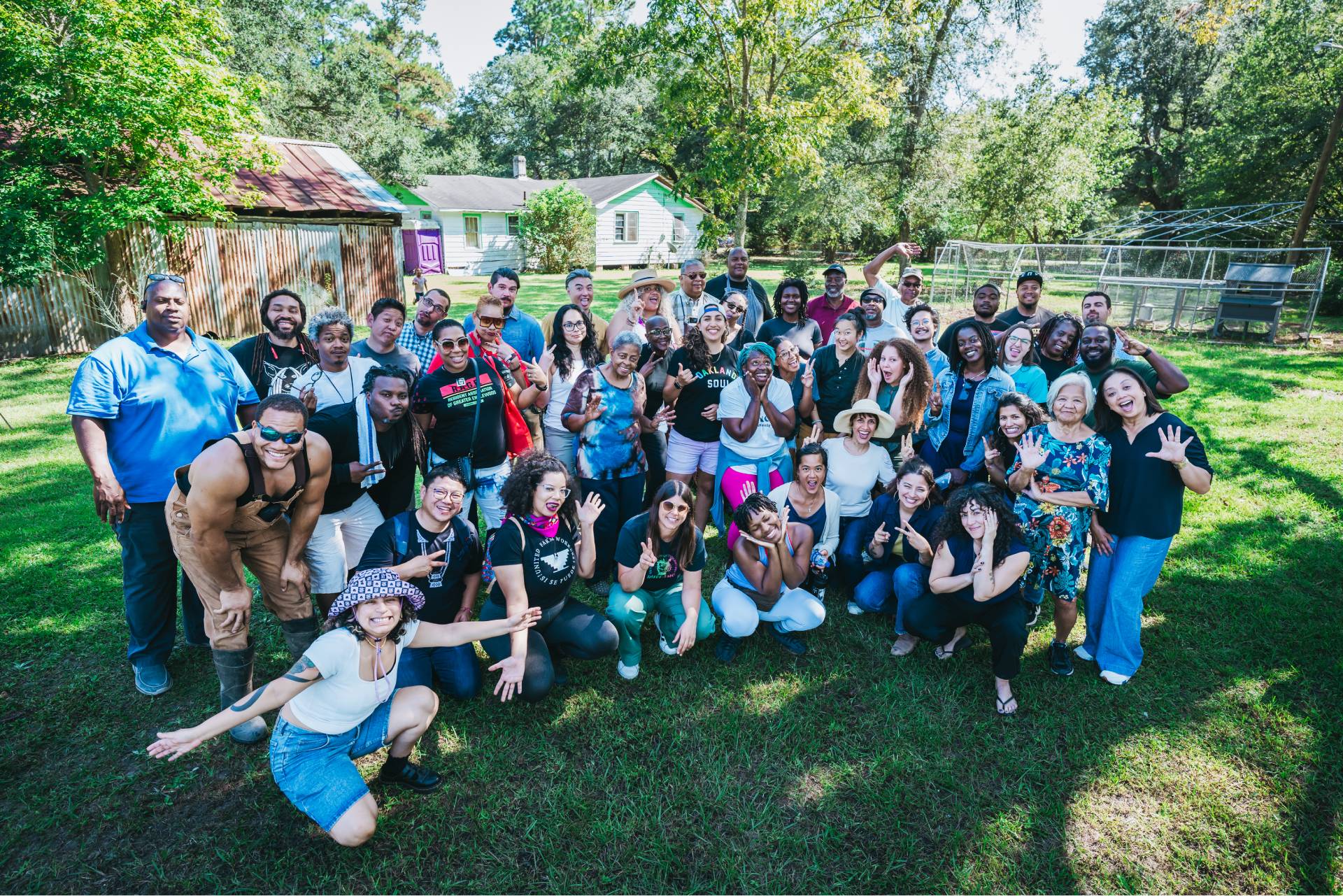 large group of smiling multiracial members of equitable food oriented development on an organic farm